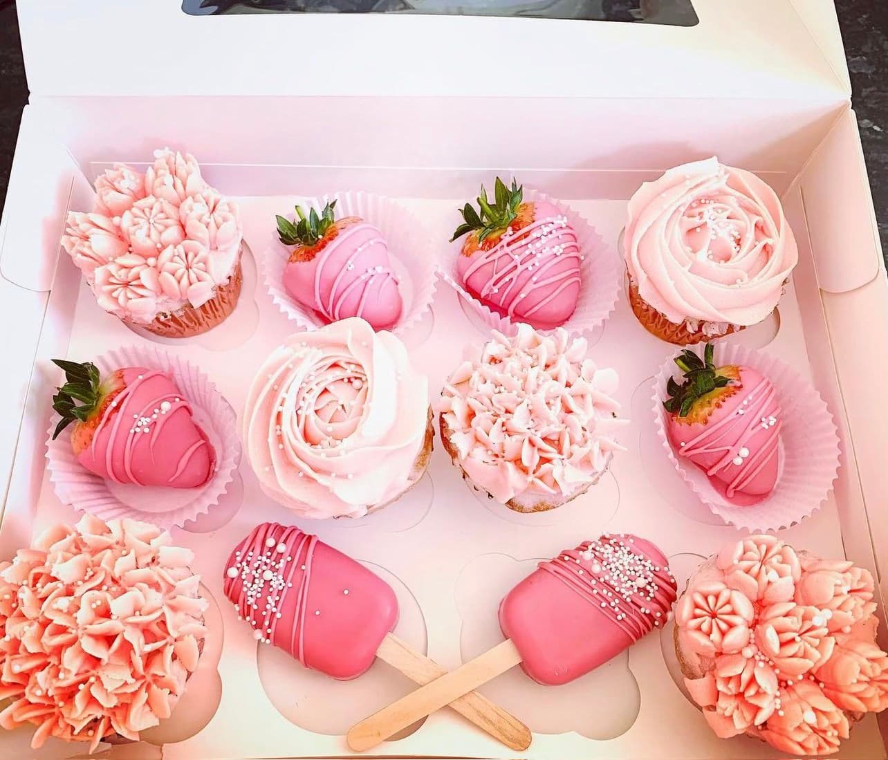 Pink flowery cupcakes, pink cake pops with cake pearls, and pink chocolate covered strawberries