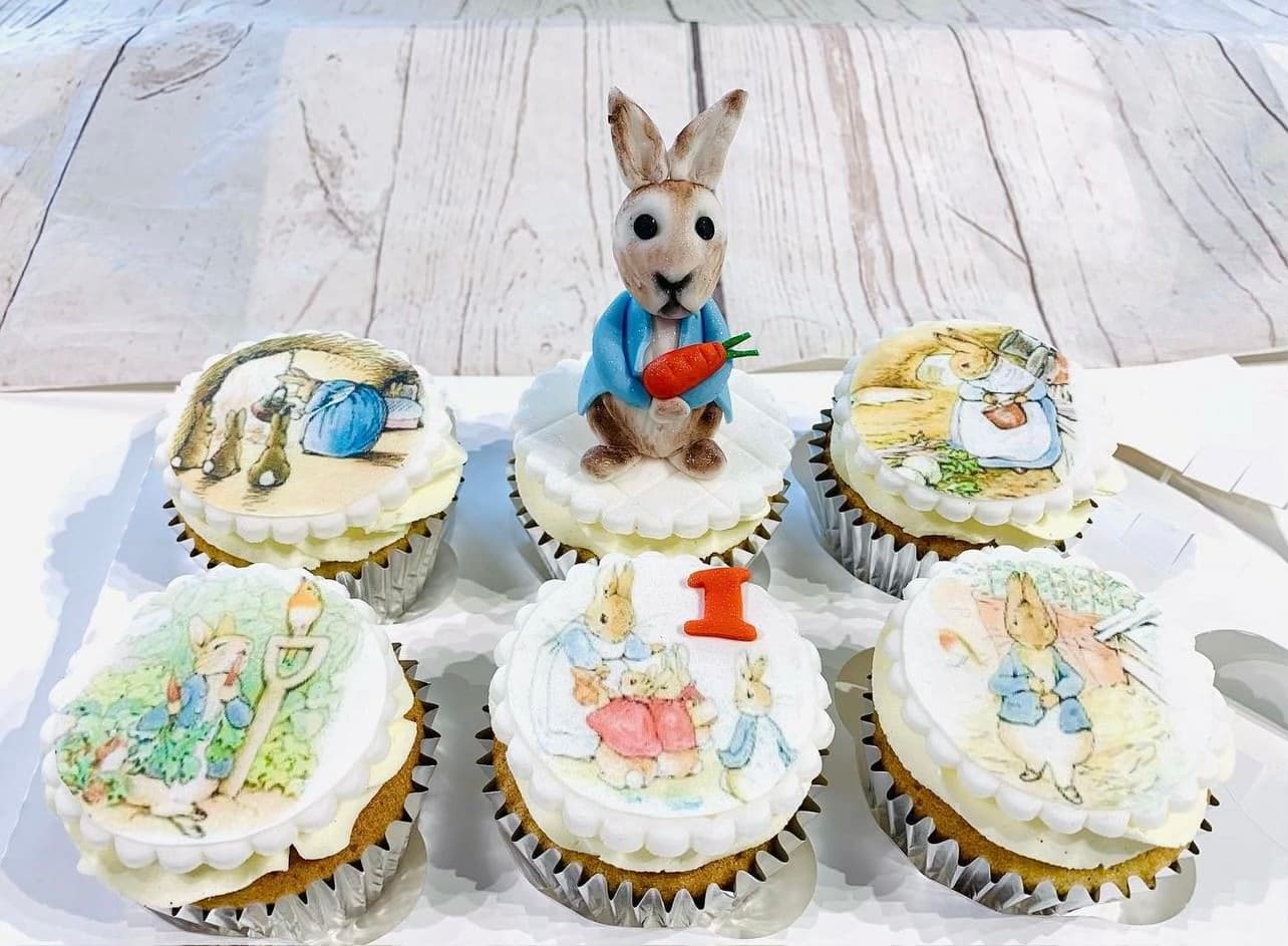 Peter Rabbit made out of fondant on top of book pictures for a first birthday